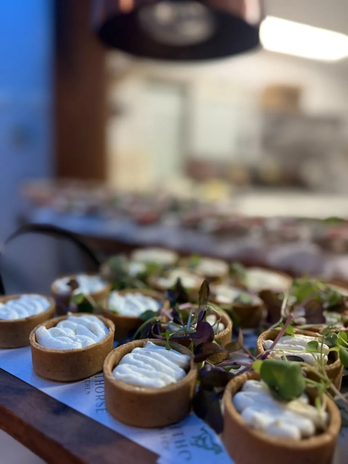 Savoury tarts with whipped filling and micro herbs on a function table