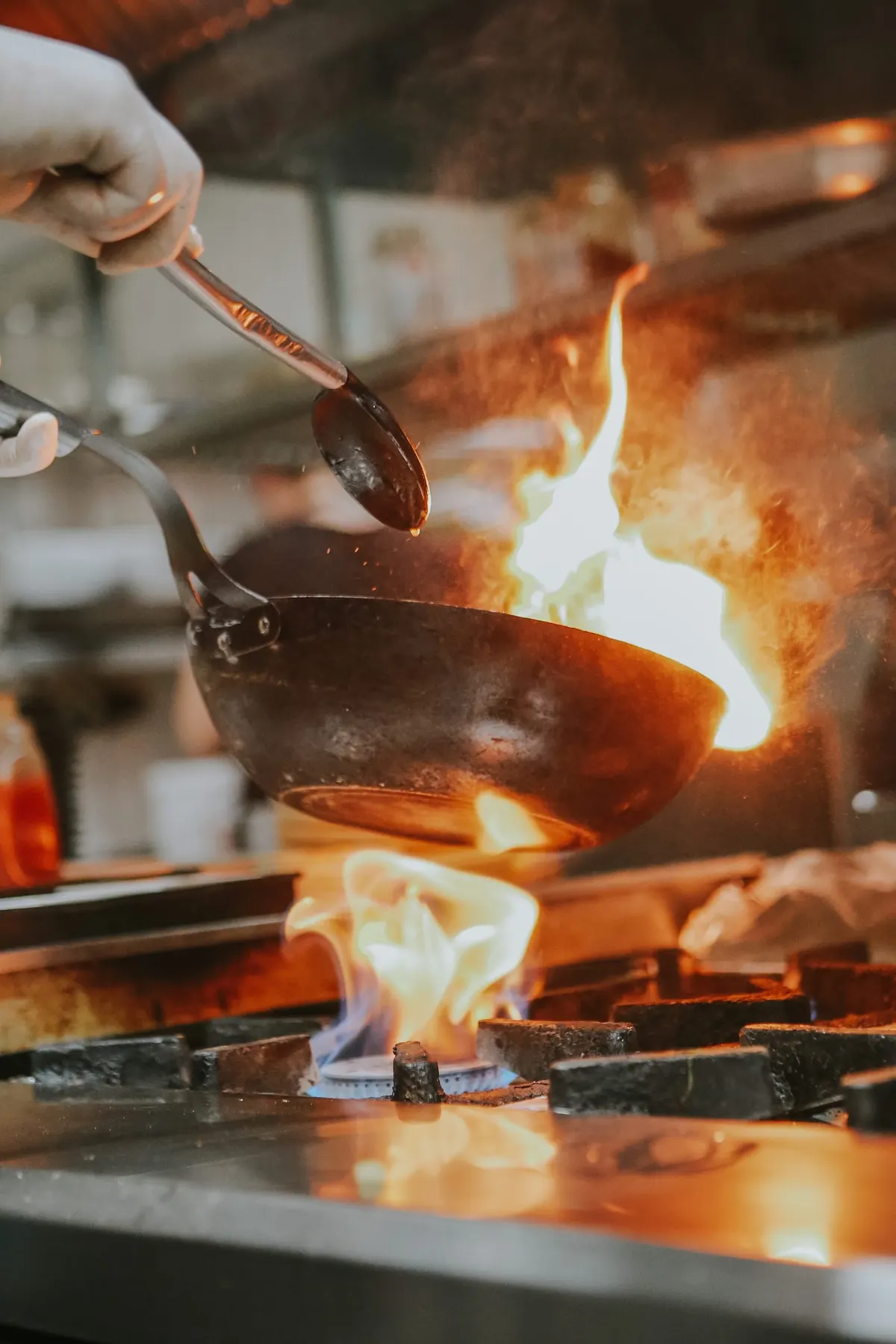 Chef flaming a pan on the kitchen line