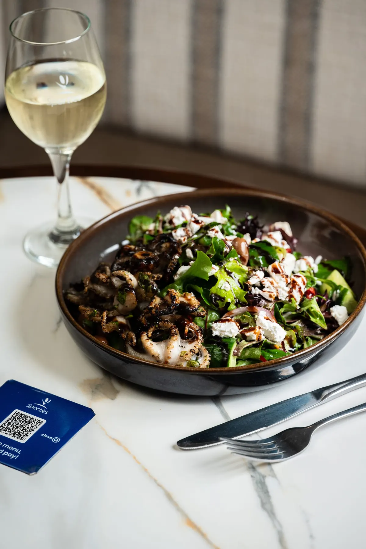 Chargrilled calamari salad with feta and a glass of white wine