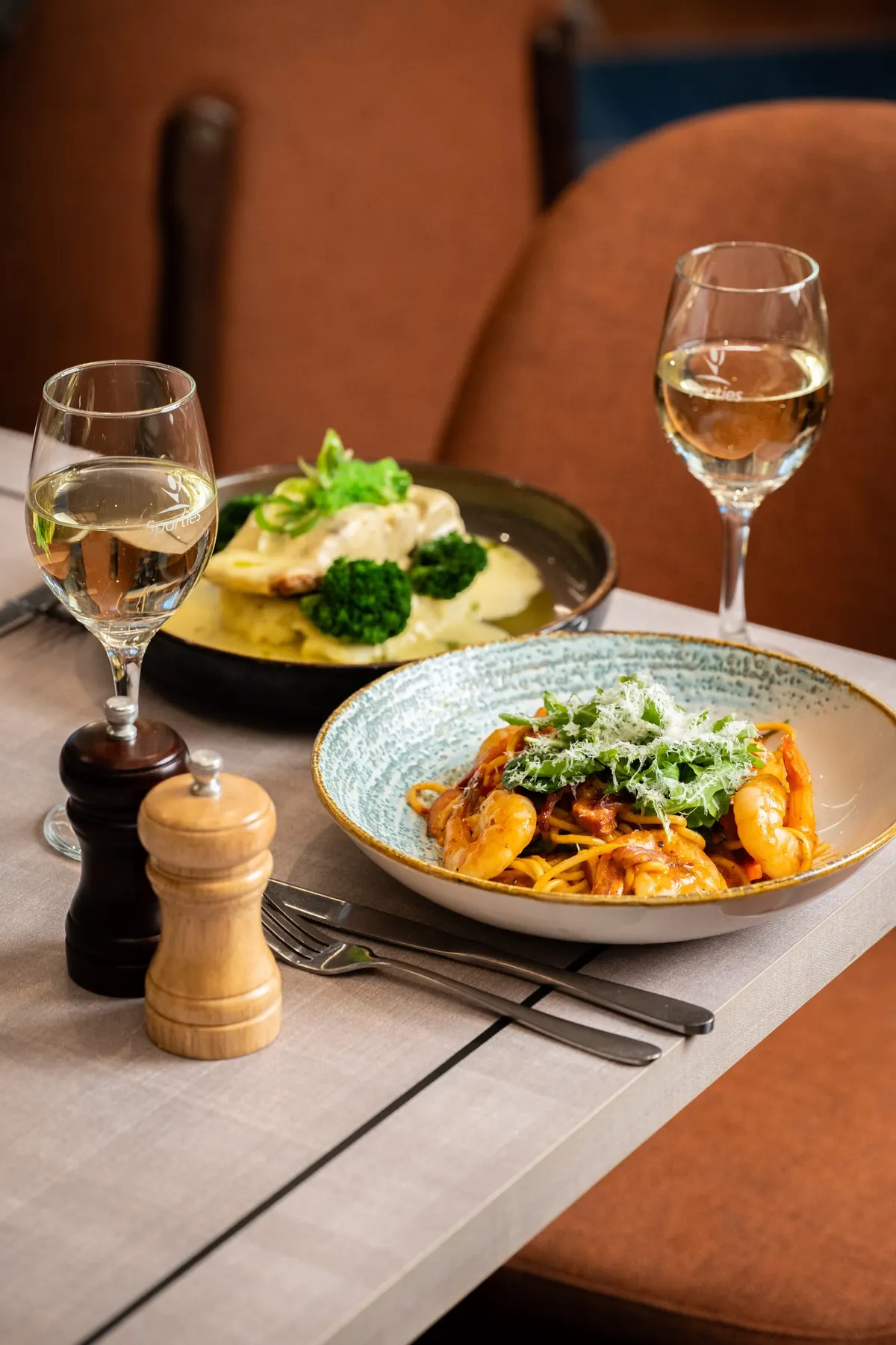 Pasta and barramundi with broccolini at a set table