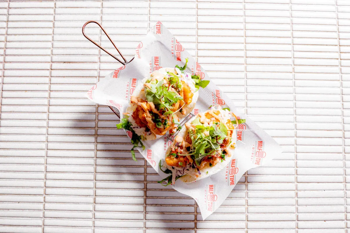 Two fresh tacos wrapped in diner paper