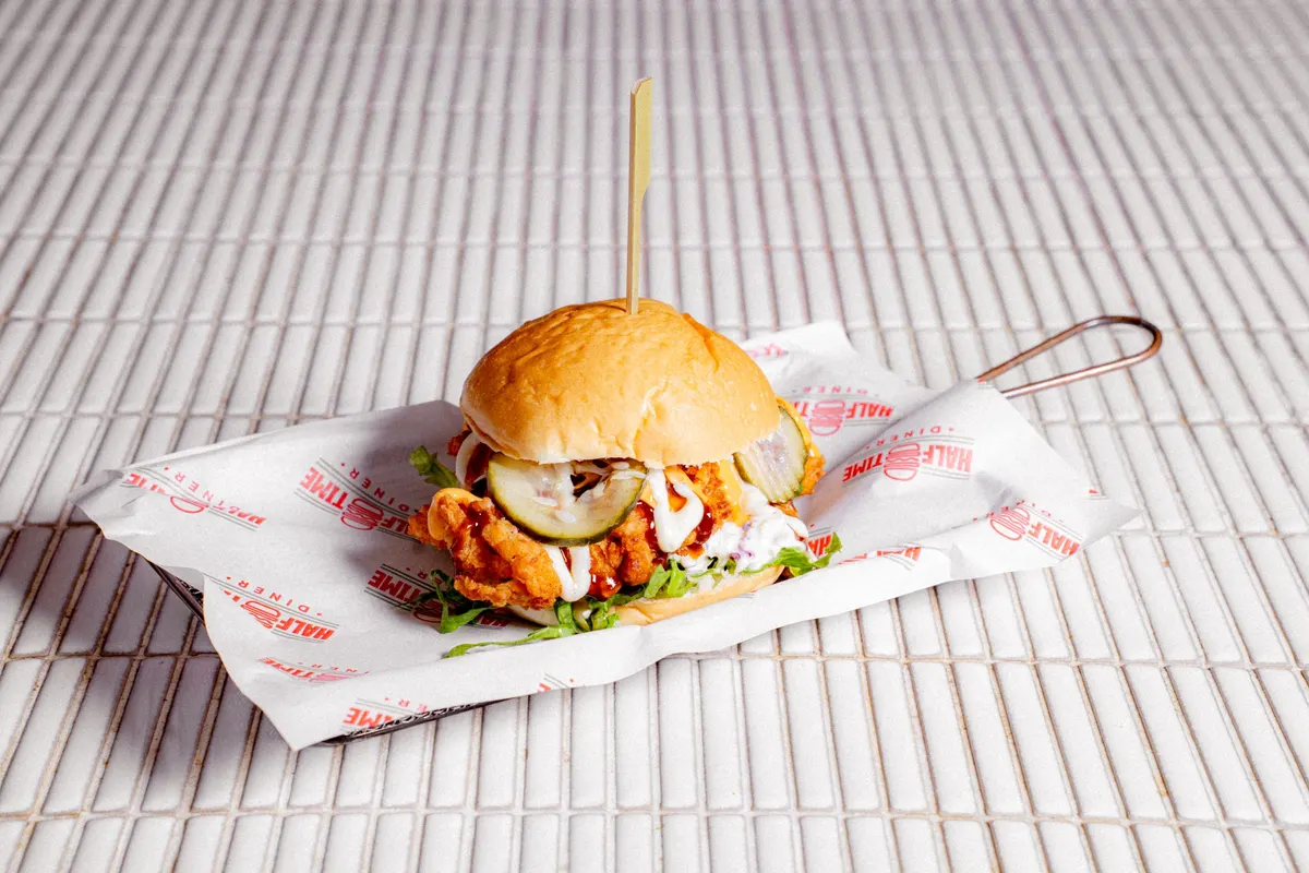 Chicken burger with pickles on a serving tray