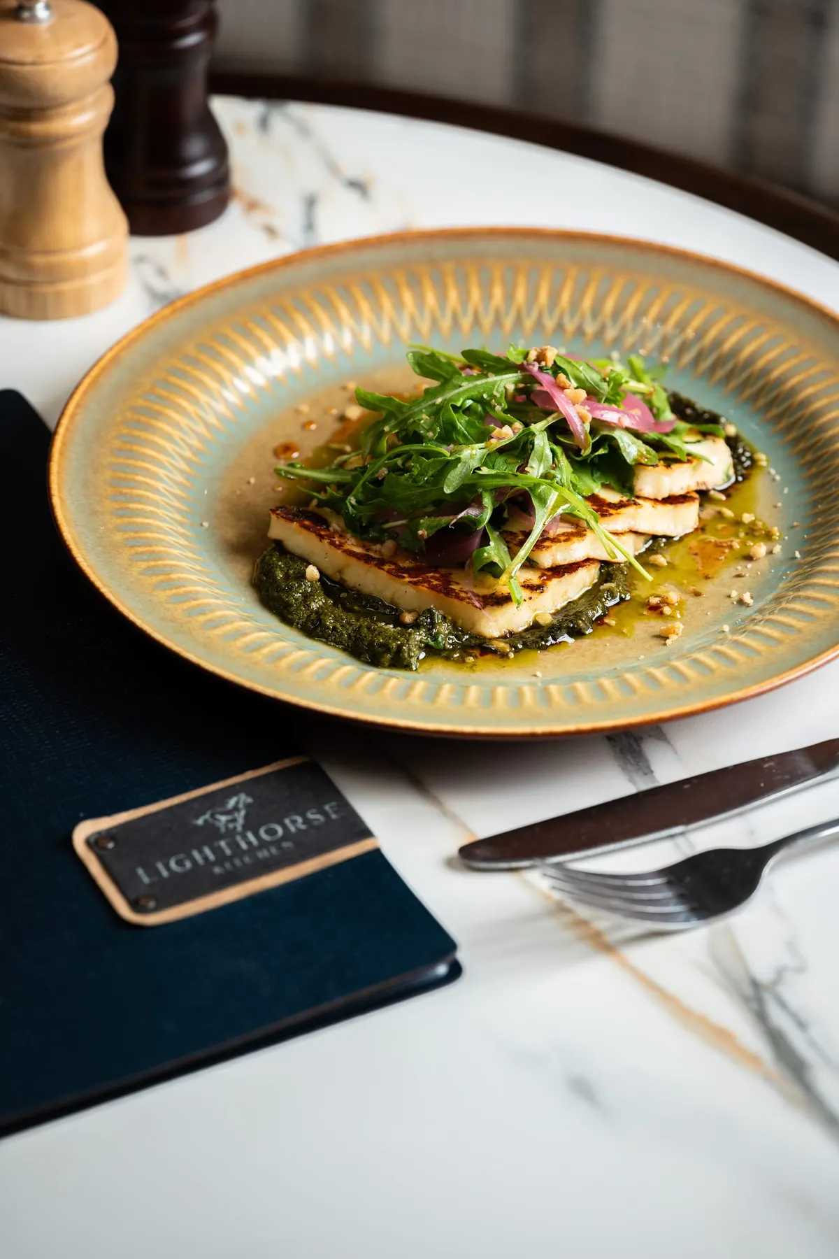 Grilled fish on greens with a fresh herb salad