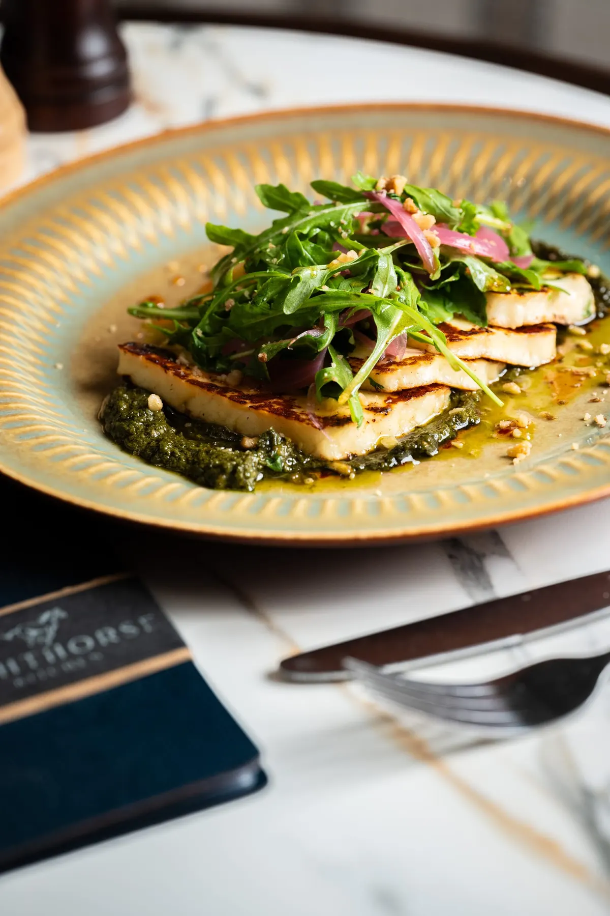 Grilled halloumi on pesto with rocket and pickled onion